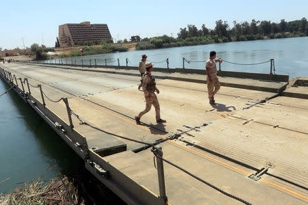 A new floating bridge installed by Iraqi military engineers that reconnects two halves of Mosul is seen in the Hawi al-Kaneesa area, south of Mosul, Iraq May 24, 2017. REUTERS/Alaa Al-Marjani