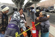 Luz Bertila Zazueta, 75, of Tijuana, right, hugs farewell to a Peruvian woman and her four children whose numbers were called, Thursday, Sept. 26, 2019, to claim asylum at a border crossing in San Diego. Zazueta persuaded a neighbor to let the family live in his empty house for free during their six-month wait in Tijuana. The Trump administration played "bait and switch" by instructing migrants to wait in Mexico for an opportunity to apply for asylum before imposing sharp restrictions on eligibility, attorneys said in a court filing Thursday. (AP Photo/Elliot Spagat)