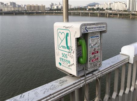 A telephone booth named "SOS Telephone Of Life" is seen on the railing on the Mapo Bridge, one of 25 bridges over the Han River, in central Seoul September 27, 2013. REUTERS/Lee Jae-Won