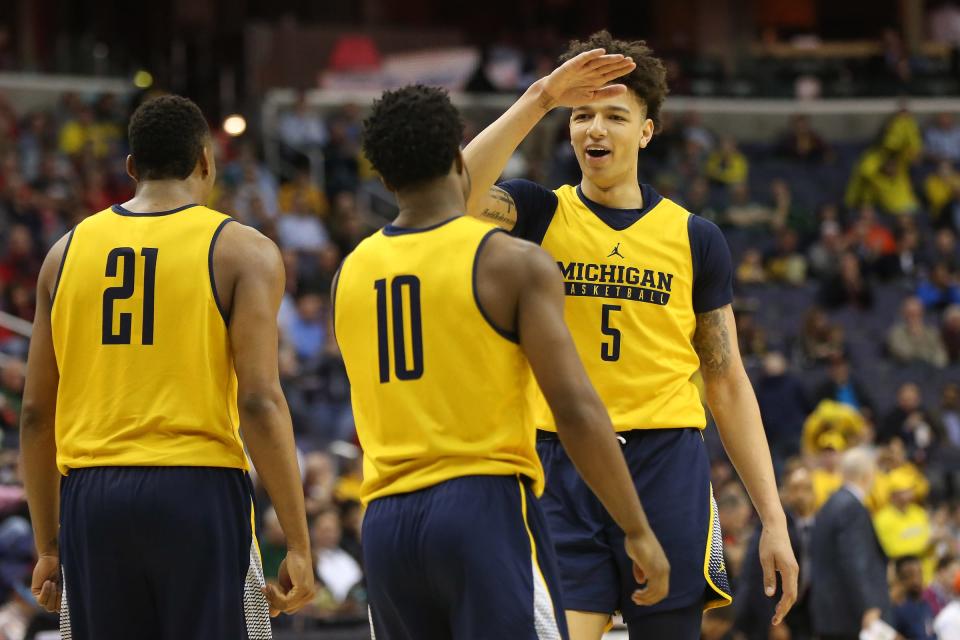 Michigan Wolverines forward D.J. Wilson (5) celebrates with guard Derrick Walton Jr. (10) after a call against Illinois during the second half of U-M's 75-55 win in the Big Ten tournament March 9, 2017 at Verizon Center.
