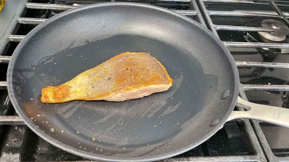 Nonstick pan on stove with seared salmon filet