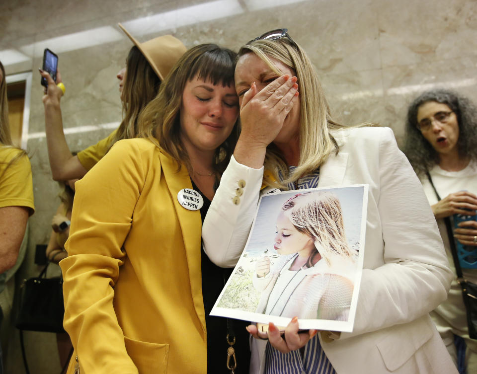 FILE — In this June 20, 2019 file photo Jessica Purciful, left, and Angela Hicks, right, who both opposed a measure that would give public health officials oversight of doctors that may be giving fraudulent medical exemptions from vaccinations console each other after the bill SB276 was approved by the Assembly Health Committee at the Capitol in Sacramento, Calif. Gov. Gavin Newsom signed the bill, which will take effect in 2020, that allows officials to investigate doctors who grant more than five medical exemptions in a year and schools with vaccination rates under 95%. (AP Photo/Rich Pedroncelli, File)
