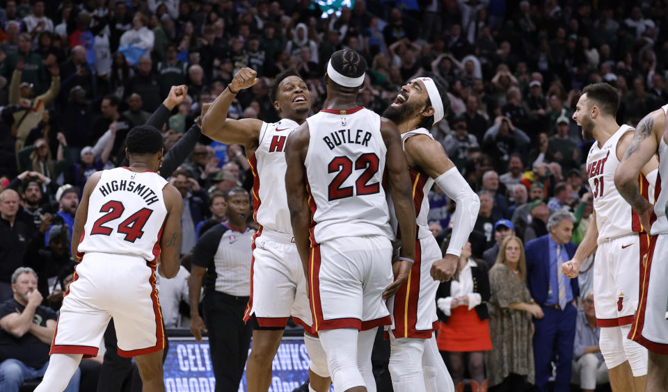 Miami Heat's Jimmy Butler (22), Kyle Lowry, center left, and Gabe Vincent center right, react at the end of overtime against the Milwaukee Bucks in Game 5 of a first-round NBA basketball playoff series Wednesday, April 26, 2023, in Milwaukee. The Heat won 128-126, eliminating the Bucks from the playoffs.(AP Photo/Jeffrey Phelps)