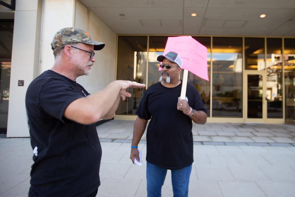 Chad Manspeaker, left, a union organizer with IBEW Local 304, speaks with Bruce Fouts, a chemical analysis at Jeffrey Energy Center, during an informational picket Monday in front of Evergy's Topeka building.