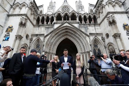 Charlie Gard's parents Connie Yates and Chris Gard read a statement at the High Court after a hearing on their baby's future, in London. REUTERS/Peter Nicholls