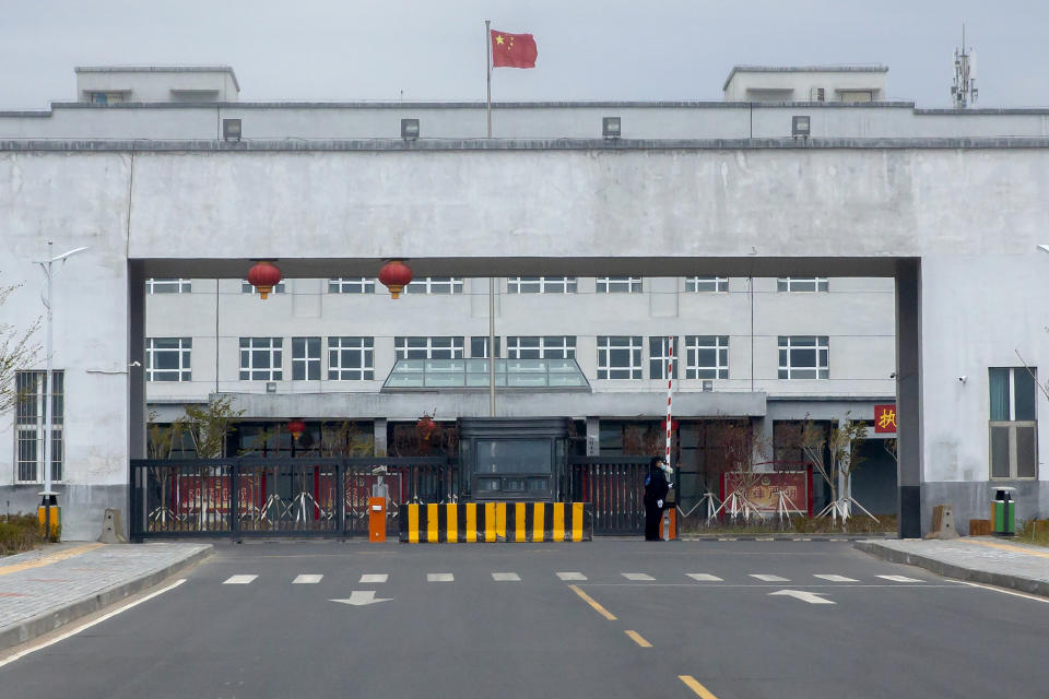 FILE - Police officers stand at the outer entrance of the Urumqi No. 3 Detention Center in Dabancheng in western China's Xinjiang Uyghur Autonomous Region on April 23, 2021. State officials took AP journalists on a tour of a "training center" turned detention site in Dabancheng sprawling over 220 acres and estimated to hold at least 10,000 prisoners - making it by far the largest detention center in China and among the largest on the planet. (AP Photo/Mark Schiefelbein, File)