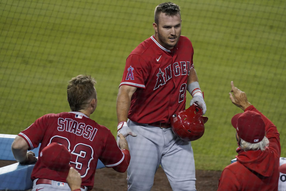 Los Angeles Angels' Mike Trout, center, returns to the dugout after hitting a three-run home run during the third inning of the team's baseball game against the Los Angeles Dodgers on Friday, Sept. 25, 2020, in Los Angeles. (AP Photo/Ashley Landis)