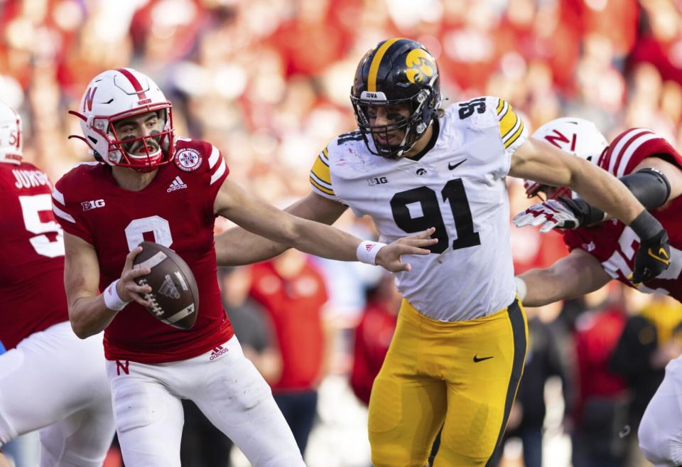 Iowa's Lukas Van Ness, right, tackles Nebraska quarterback Logan Smothers during a game in November 2021.