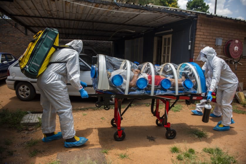 PRETORIA, SOUTH AFRICA - JANUARY 15: Members of the Tshwane Special Infectious Unit on COVID-19 wearing personal protective equipment (PPE) pick up a suspected COVID-19 patient on January 15, 2021 in Pretoria, South Africa. The Special Infectious Unit ambulance is equipped with an isolation chamber with a negative pressure filtration system. (Photo by Alet Pretorius/Gallo Images via Getty Images)