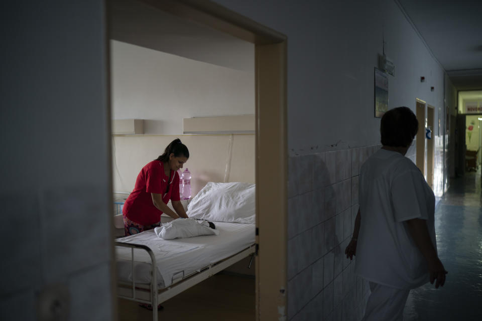 In this Nov. 15, 2018, photo, a nurse stands outside the room as Paulina Balazova prepares the clothes of her newborn baby at a hospital in Trebisov, Slovakia. An investigation by The Associated Press has found that women and their newborns in Slovakia are routinely, unjustifiably and illegally detained in hospitals across the European Union country. (AP Photo/Felipe Dana)