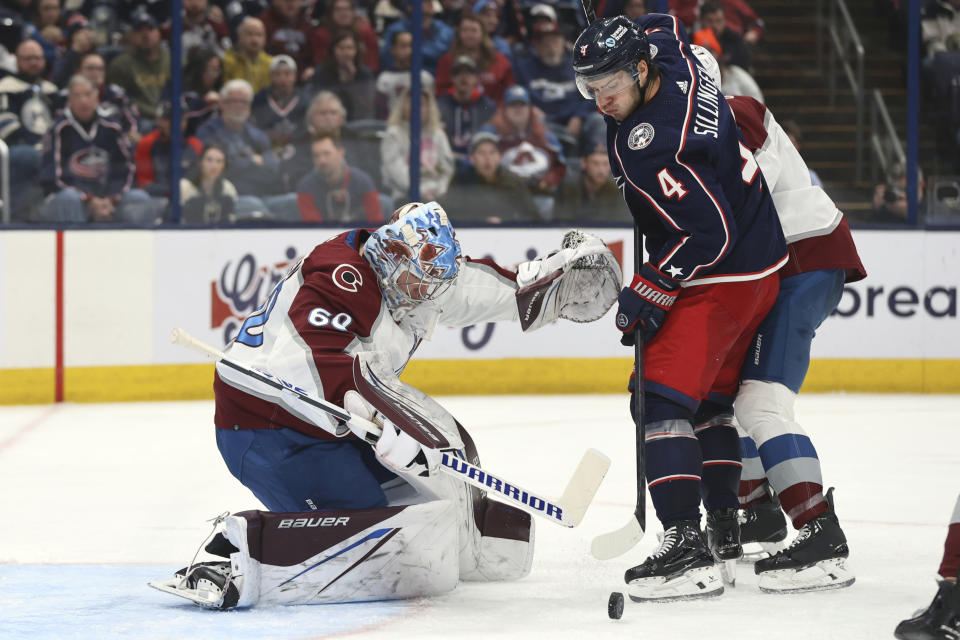 Colorado Avalanche goalie Justus Annunen, left, makes a stop in front of Columbus Blue Jackets forward Cole Sillinger during the second period of an NHL hockey game in Columbus, Ohio, Monday, April 1, 2024. (AP Photo/Paul Vernon)