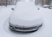 A car covered in snow is pictured during a snowstorm in Quebec City, December 15, 2013. Between 15 and 30cm of snow are expected to fall on the different regions of eastern Canada today according to Environment Canada. REUTERS/Mathieu Belanger (CANADA - Tags: ENVIRONMENT)