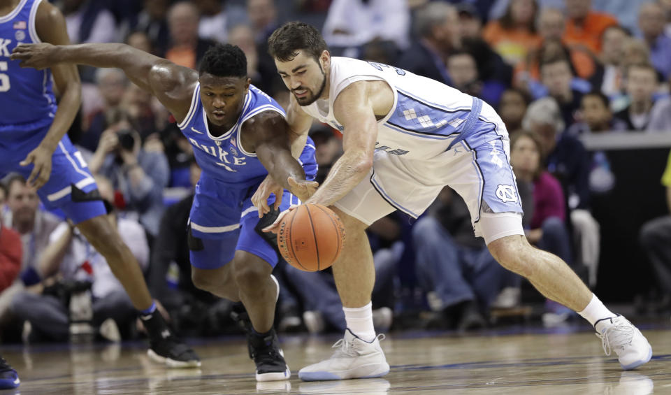 Duke's Zion Williamson, left, and North Carolina's Luke Maye, right, chase a loose ball during the first half of an NCAA college basketball game in the Atlantic Coast Conference tournament in Charlotte, N.C., Friday, March 15, 2019. (AP Photo/Chuck Burton)