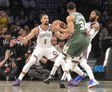 Milwaukee Bucks forward Giannis Antetokounmpo, center, drives to the basket on Brooklyn Nets guards Kyrie Irving , right, and Spencer Dinwiddie, left, during a NBA basketball game, Saturday Jan. 18, 2020 in New York. (AP Photo/Bebeto Matthews)