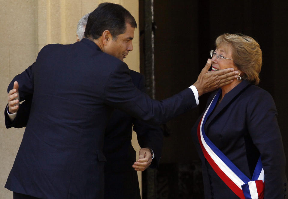 Ecuador's President Rafael Correa, front left, is received by Chilean Foreign Minister Heraldo Munoz and Chile's newly sworn-in President Michelle Bachelet, on the front steps of the Cerro Castillo presidential residence, in Vina del Mar, Chile, Tuesday, March 11, 2014. Bachelet, who led Chile from 2006-2010, was sworn-in as president on Tuesday. (AP Photo/Luis Hidalgo)