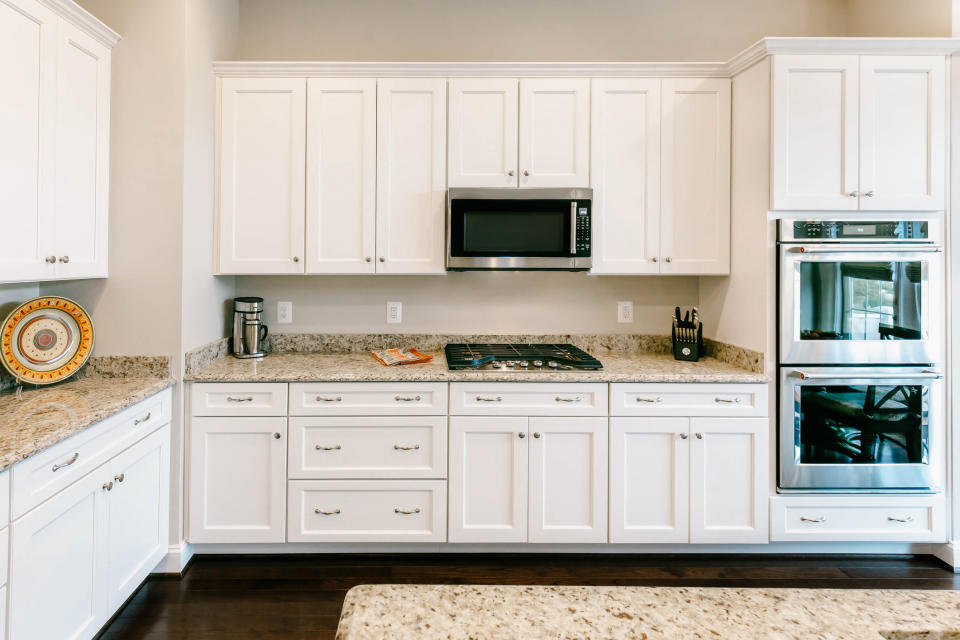 A kitchen with cabinets that don't go up to the ceiling