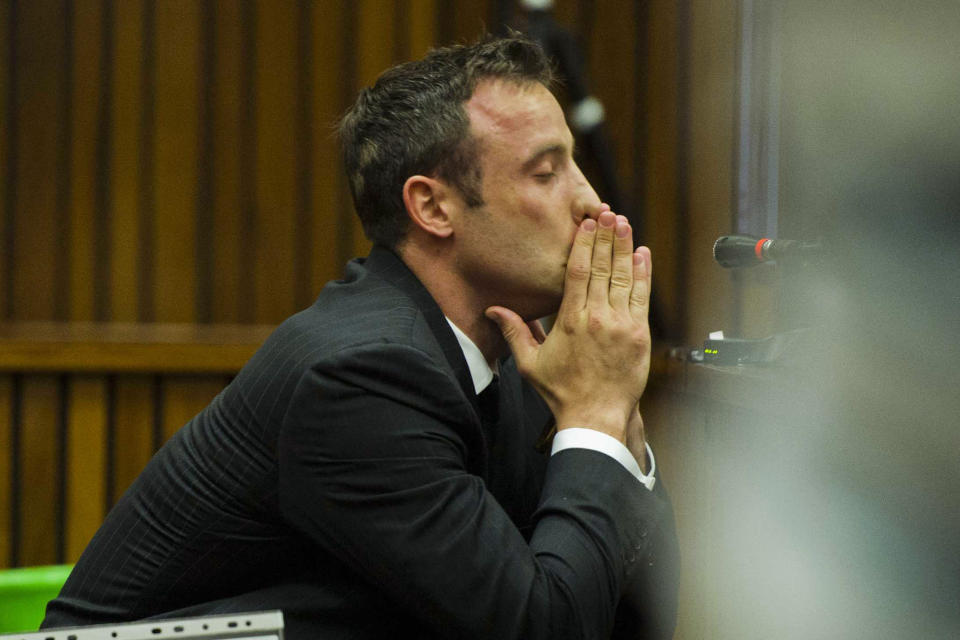 Oscar Pistorius covers his mouth with his hands as he listens to forensic evidence during his trial in court in Pretoria, South Africa, Thursday, March 13, 2014. Pistorius is charged with the shooting death of his girlfriend Reeva Steenkamp, on Valentines Day in 2013. (AP Photo/Alet Pretorius, Pool)