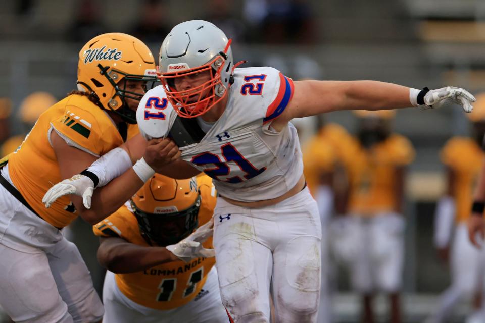 Bolles' ﻿﻿﻿Trent Carter (21) looks to defend pressured by Ed White's Elijah Harper (18), left, and Joshua Macklin (11) during the second quarter of a high school football scrimmage Friday, May 26, 2023 at Ed White High School in Jacksonville, Fla. The Bolles Bulldogs held off the Ed White Commanders 23-21. 