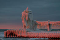 The lighthouse in St. Joseph, Michigan, has become an ice sculpture. Yesterday (January 26, 2013), after a day of cloudy skies, there was a break in the clouds just above the horizon to the west. As the sun slipped below the the bank of clouds the ice-covered lighthouse came alive in hues of pink. This was one of the most stunning natural wonders I've ever seen. (Photo and caption Courtesy Lisa Rundell / National Geographic Your Shot) <br> <br> <a href="http://ngm.nationalgeographic.com/your-shot/weekly-wrapper" rel="nofollow noopener" target="_blank" data-ylk="slk:Click here;elm:context_link;itc:0;sec:content-canvas" class="link ">Click here</a> for more photos from National Geographic Your Shot.