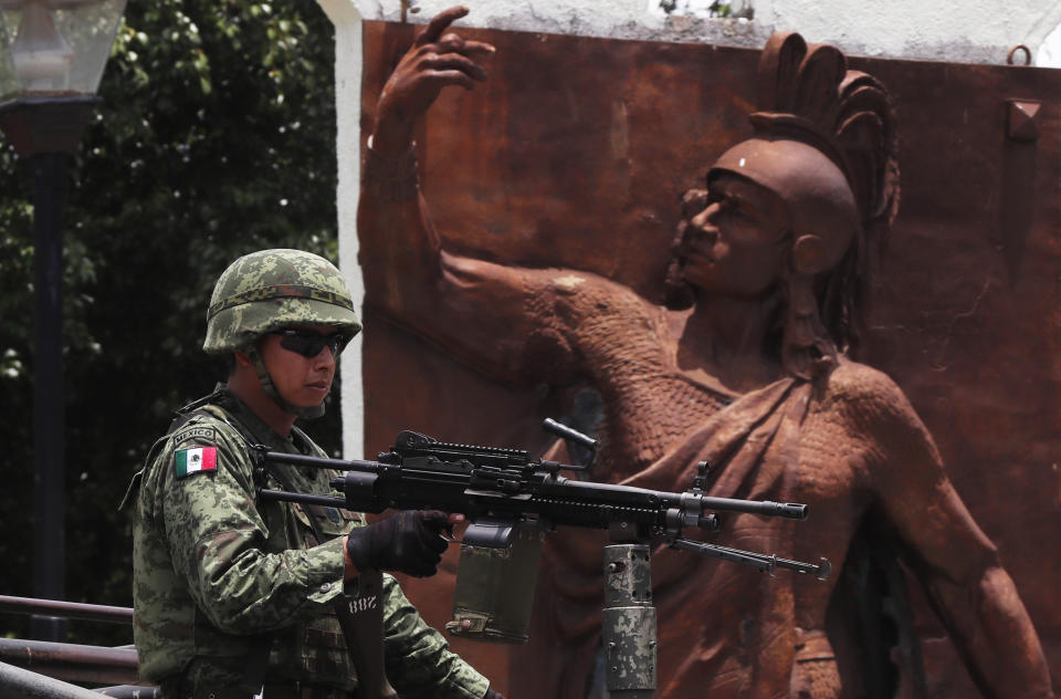 A Mexican soldier mans his machine gun as he rides in the back of a pick up truck, in Tapachula, Mexico, Tuesday, June 11, 2019. Mexican officials say they are beginning deployment of 6,000 National Guard troops for immigration enforcement, an accelerated commitment made as part of an agreement with the United States last week to head off threatened U.S. tariffs on imports from Mexico. (AP Photo/Marco Ugarte