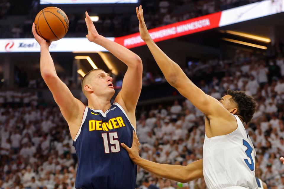 The Denver Nuggets' Nikola Jokic (15) goes to the basket against the Minnesota Timberwolves' Karl-Anthony Towns.