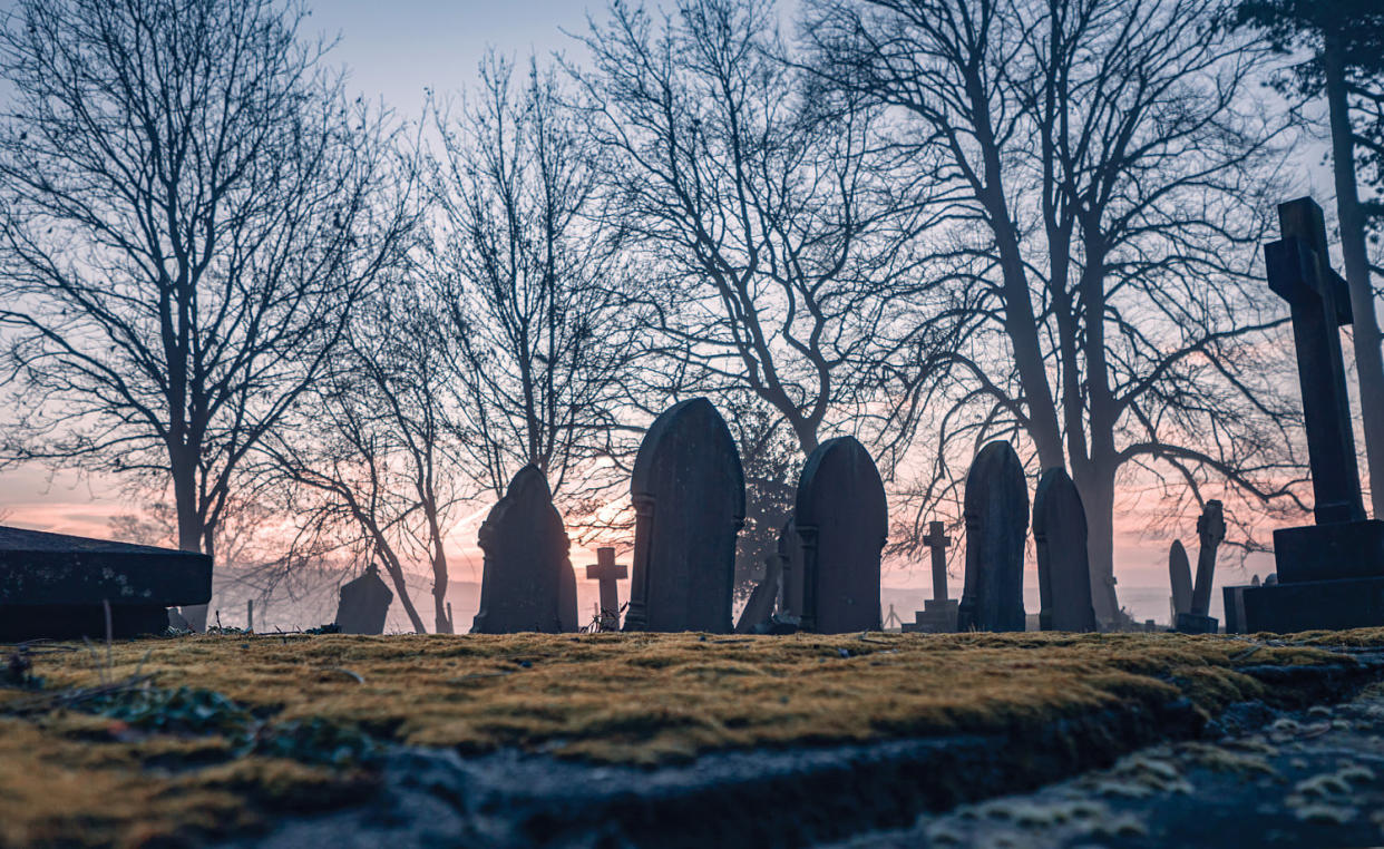 Headstones in a misty graveyard. (Capchure / Getty Images)
