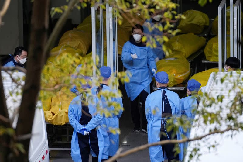 A staff member walks next to several body bags at a funeral home, as coronavirus disease (COVID-19) outbreaks continue in Shanghai