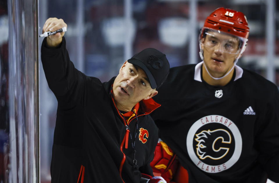 Calgary Flames head coach Ryan Huska, left, gives instruction as Nikita Zadorov looks on during NHL hockey training camp practice in Calgary, Thursday, Sept. 21, 2023. (Jeff McIntosh/The Canadian Press via AP)