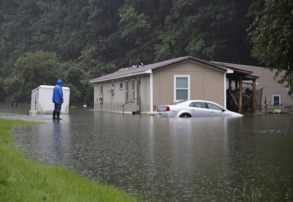 FILE - A man views flood damage in Bridgewater, Vt., that submerged vehicles and threatened homes Monday, July 10, 2023. Vermont has become the first state to enact a law requiring fossil fuel companies to pay a share of the damage caused by climate change, Thursday, May 30, 2024 after the state suffered catastrophic summer flooding and damage from other extreme weather. (AP Photo/Hasan Jamali, File)