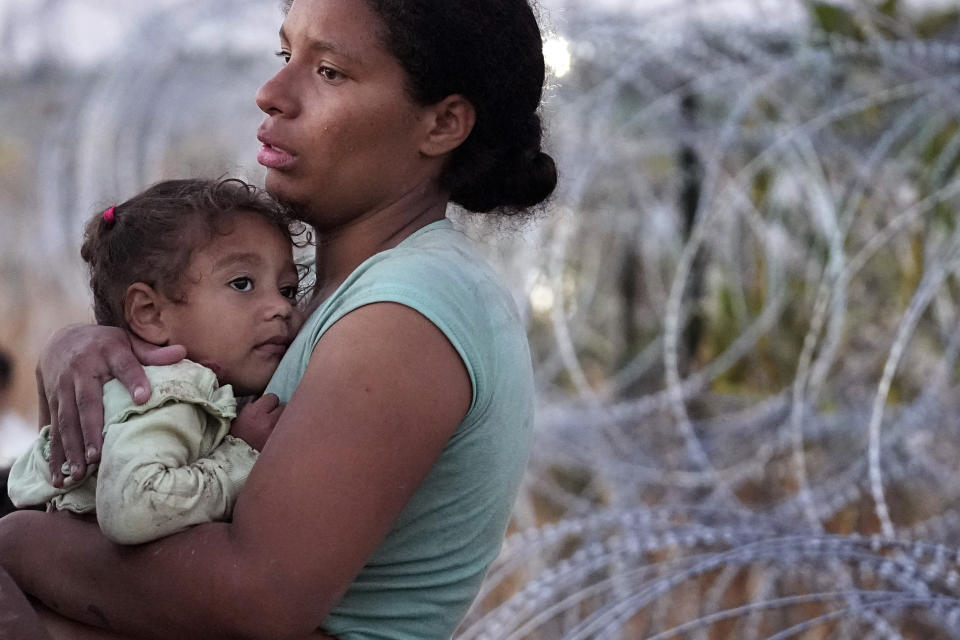 FILE - A woman carries her child after she and other migrants crossed the Rio Grande and entered the U.S. from Mexico to be processed by U.S. Customs and Border Protection, Saturday, Sept. 23, 2023, in Eagle Pass, Texas. (AP Photo/Eric Gay, File)