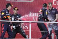Winner Red Bull driver Max Verstappen of the Netherlands, right, celebrates after winning with second place Red Bull driver Sergio Perez of Mexico, left, and third place Mercedes driver George Russell of Britain on the podium after the Azerbaijan Formula One Grand Prix at the Baku circuit, in Baku, Azerbaijan, Sunday, June 12, 2022. (AP Photo/Sergei Grits)
