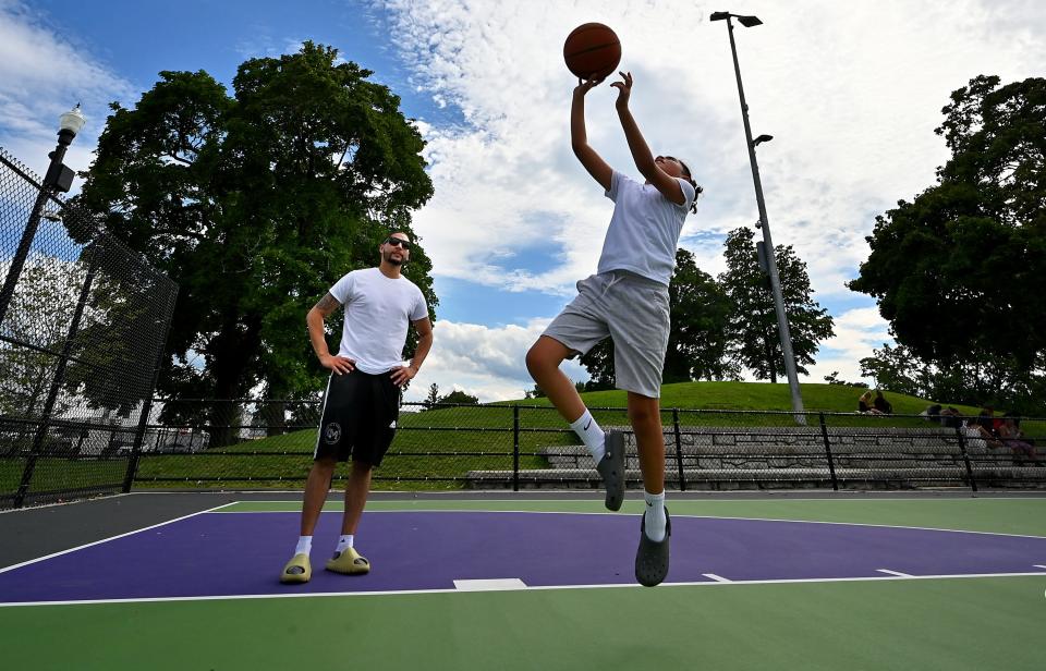 Anthony Orama watches his son Kaiden, 10, execute a layup at Crompton Park basketball courts.
