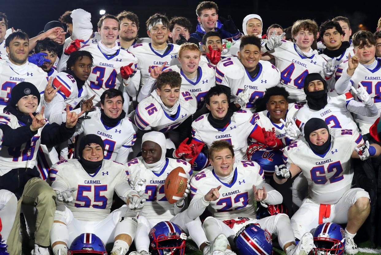 Carmel players celebrate their victory over Christian Brothers Academy in the Class AA state semifinal playoff game at Middletown High School Nov. 25, 2023.