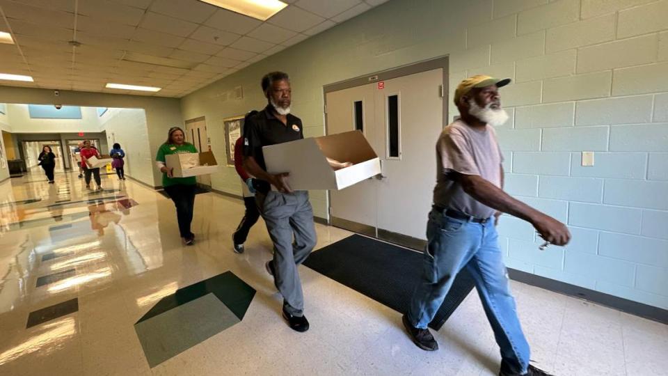 Volunteers deliver boxes of Thanksgiving food to waiting cars at Lincoln Memorial Middle School in Palmetto on Tuesday.