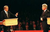 FILE PHOTO: President Clinton (R) leans on his podium as Republican presidential nominee Bob Dole gestures while..