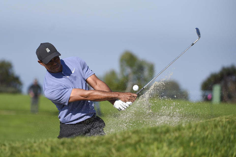 Tiger Woods hits out of the bunker on the eleventh hole of the North Course at Torrey Pines Golf Course during the first round of the Farmers Insurance golf tournament, Thursday, Jan. 23, 2020, in San Diego. (AP Photo/Denis Poroy)