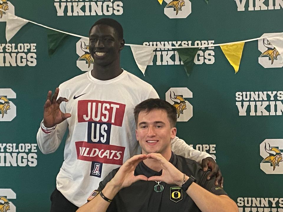 Sunnyslope quarterback Luke Moga signs with Oregon as his friend, Apollo running back and Arizona signee Adam Mohammed looks oh.