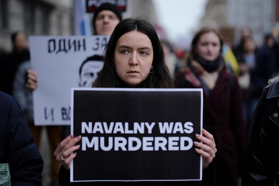 People attend a protest march near the Russian emabssy in Berlin, Sunday, Feb. 18, 2024.