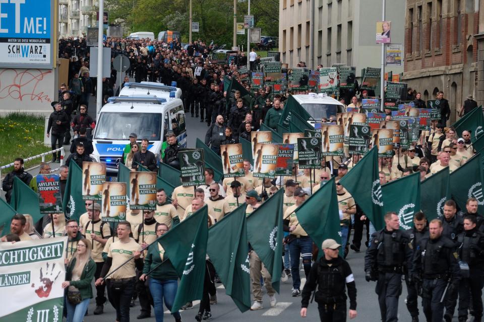 Protestors march with flags during a demonstration of the far-right party 'The third way' in Plauen, Germany, Wednesday, May 1, 2019. (Sebastian Willnow/dpa via AP)