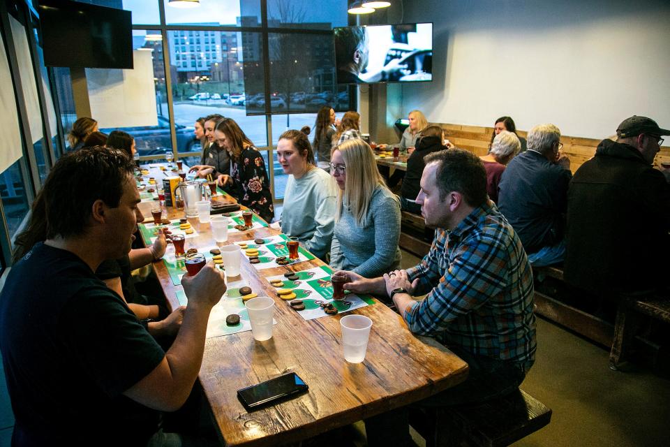 People sample a variety of brews and Girl Scout Cookies during an event, Thursday, March 24, 2022, at Backpocket Brewing in Coralville, Iowa.