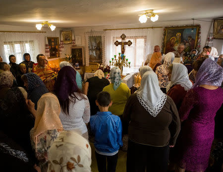 Faithfuls of the Ukrainian Orthodox Church of the Kiev Patriarchate attend a service at a caretaker's lodge in the village of Ptycha, Ukraine May 13, 2018. Picture taken May 13, 2018. REUTERS/Gleb Garanich
