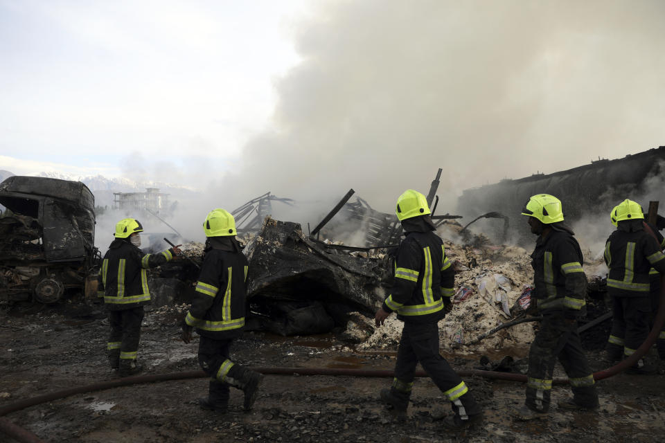 Firefighters work to extinguish burning fuel tankers in Kabul, Afghanistan, Sunday, May 2, 2021. A fire roared through several fuel tankers on the northern edge of the Afghan capital late Saturday, injuring at least 10 people and plunging much of the city into darkness, officials said. (AP Photo/Rahmat Gul)