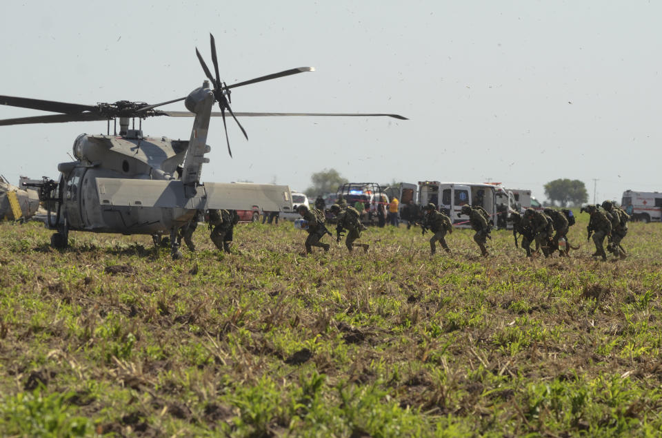 Mexican marines board a helicopter after working on the zone where other navy Blackhawk helicopter crashed after supporting those who conducted the capture of drug lord Rafael Caro Quintero, near Los Mochis, Sinaloa state, Mexico, Friday, July 15, 2022. Mexico's navy statement said multiple people aboard died. (AP Photo/Guillermo Juarez)