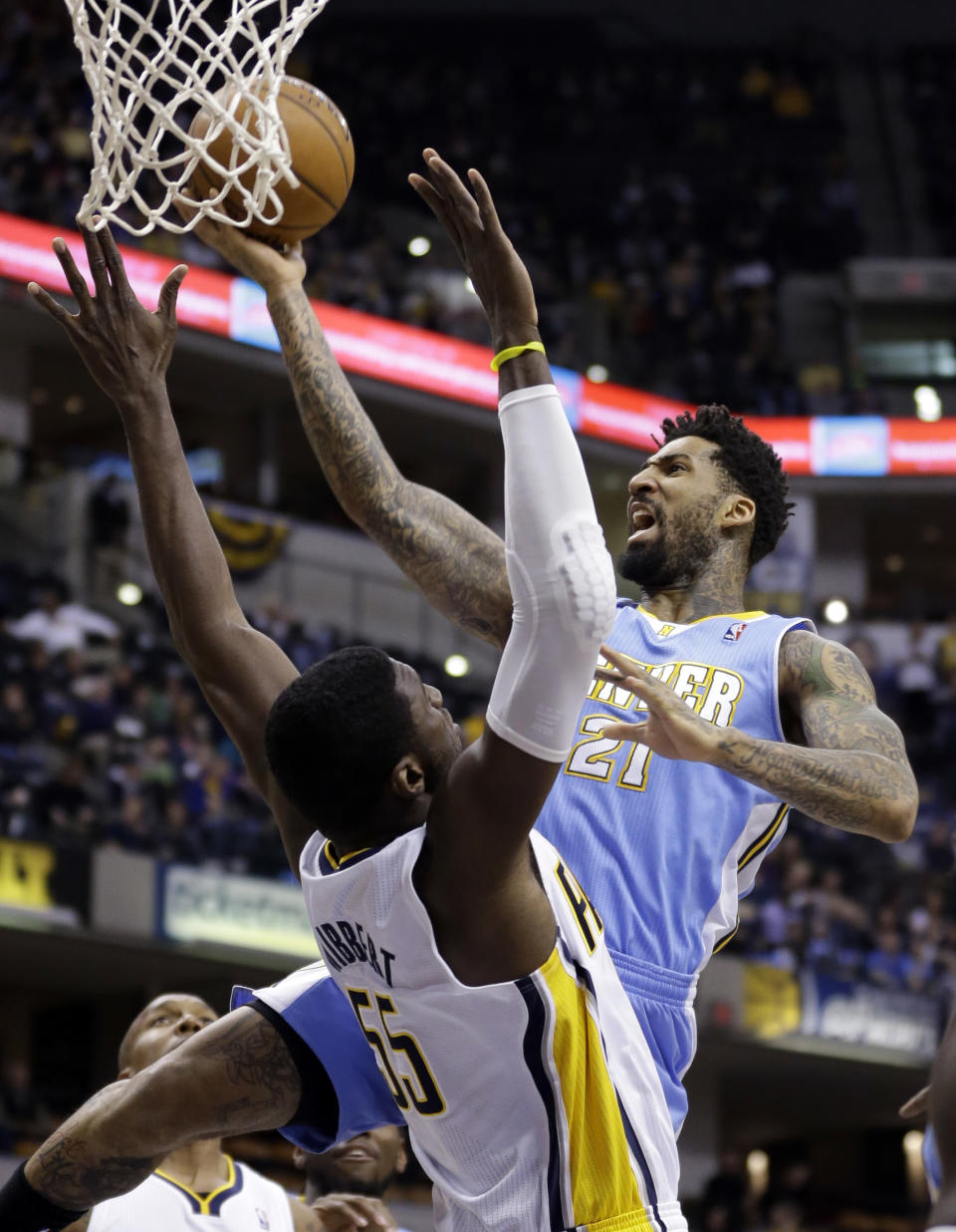 Denver Nuggets forward Wilson Chandler, right, gets a basket over Indiana Pacers center Roy Hibbert in the first half of an NBA basketball game in Indianapolis, Monday, Feb. 10, 2014. (AP Photo/Michael Conroy)