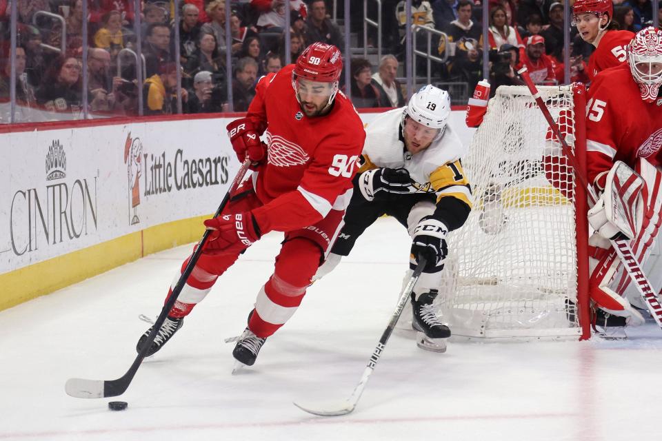 Red Wings forward Joe Veleno tries to control the puck in front of the Penguins' Alex Nylander during the first period on Saturday, April 8, 2023, at Little Caesars Arena.