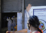 Doctors wave goodbye to a woman who has recovered from COVID-19, as she leaves an isolation center in Mumbai, India, Wednesday, July 8, 2020. India has overtaken Russia to become the third worst-affected nation by the coronavirus pandemic. (AP Photo/Rajanish Kakade)