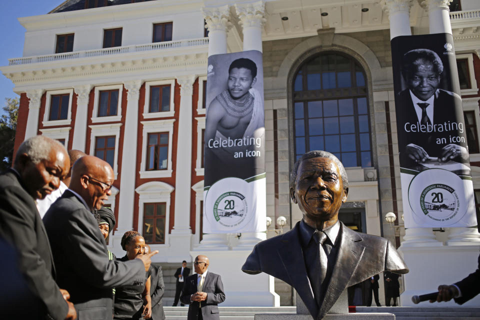 South African President Jacob Zuma, second left, points after he and other dignitaries unveiled a bust of former South African President Nelson Mandela at the South African Parliament in Cape Town, South Africa, Monday, April 28, 2014. South African President Jacob Zuma and members of the South African Parliament unveiled the bust of Mandela at Parliament, forming part of celebrations for 20-years anniversary of a democratic Parliament in South Africa after the end of white rule. (AP Photo/Schalk van Zuydam)