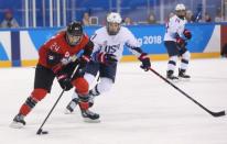 Feb 14, 2018; Gangneung, South Korea; Canada forward Natalie Spooner (24) moves the puck ahead of United States forward Hilary Knight (21) during the second period at the Pyeongchang 2018 Olympic Winter Games at Kwandong Hockey Centre. Mandatory Credit: David E. Klutho-USA TODAY Sports