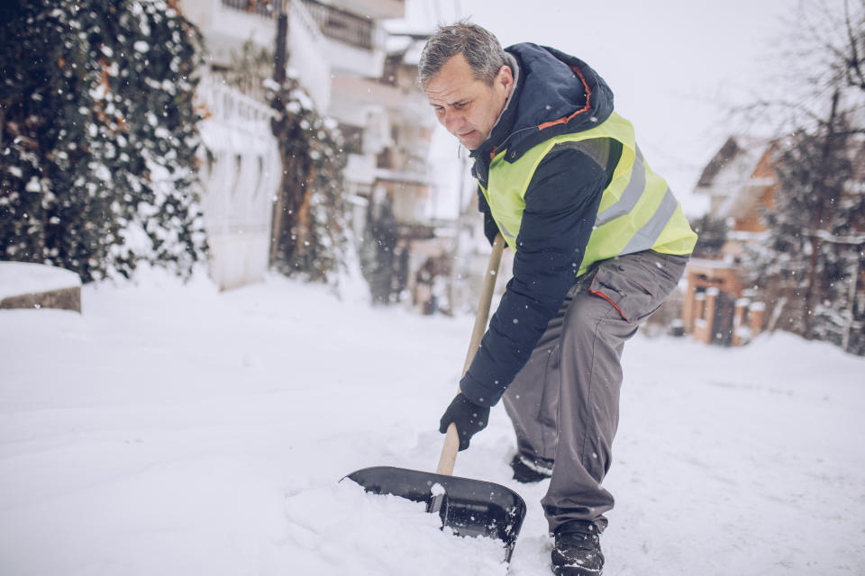 One man, prepared for clean the street full on snow, working with snow shovel.