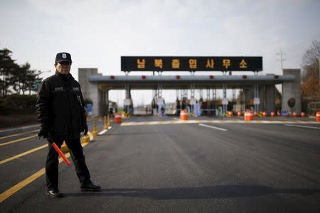 A South Korean security guard stands guard on an empty road which leads to the Kaesong Industrial Complex (KIC) at the South's CIQ (Customs, Immigration and Quarantine), just south of the demilitarised zone separating the two Koreas, in Paju, South Korea, February 11, 2016. REUTERS/Kim Hong-Ji